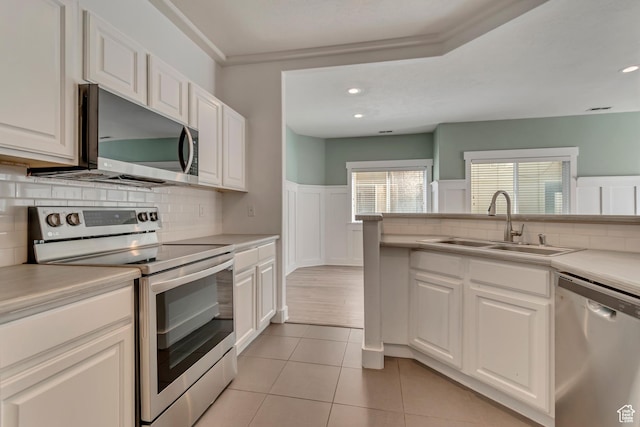 4917 W Stormy Meadow Dr, Riverton, UT 84096 - kitchen with stainless steel appliances, a sink, white cabinetry, light countertops, and decorative backsplash