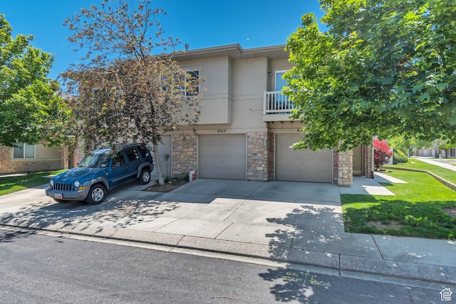 4917 W Stormy Meadow Dr, Riverton, UT 84096 - view of property featuring stone siding, a garage, concrete driveway, stucco siding, and a balcony