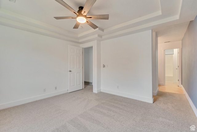 4917 W Stormy Meadow Dr, Riverton, UT 84096 - empty room featuring a tray ceiling, light carpet, ceiling fan, and baseboards