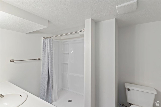 73 E 400 S, Logan, UT 84321 - bathroom featuring toilet, a textured ceiling, a stall shower, and a sink