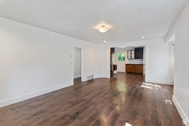 73 E 400 S, Logan, UT 84321 - unfurnished living room with dark wood-type flooring, a textured ceiling, baseboards, and recessed lighting