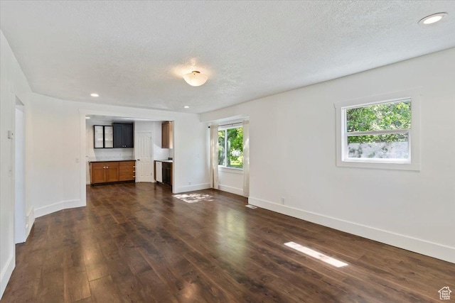 73 E 400 S, Logan, UT 84321 - unfurnished living room featuring baseboards, dark wood finished floors, a textured ceiling, and recessed lighting
