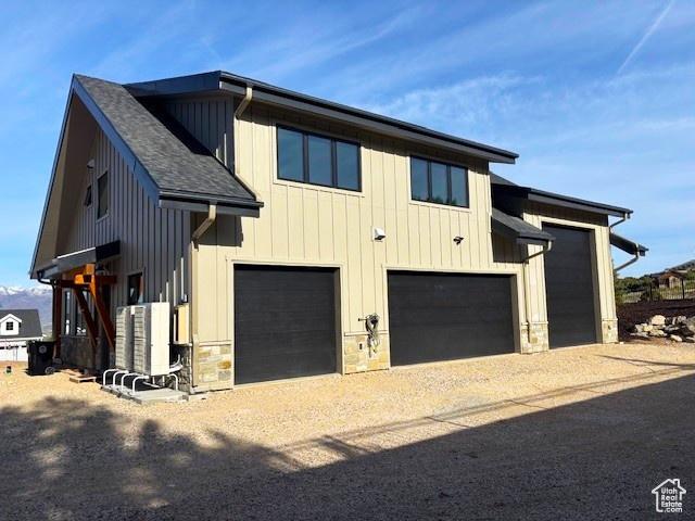2508 E 70 S Unit 4, Heber City, UT 84032 - view of home's exterior featuring stone siding, dirt driveway, roof with shingles, and board and batten siding