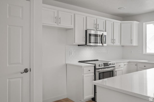 5094 W Pebblerock Cir S, West Jordan, UT 84081 - kitchen with stainless steel appliances, decorative backsplash, light countertops, and white cabinetry