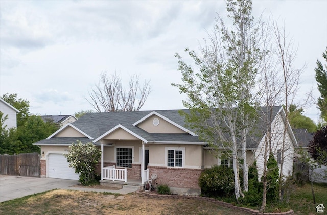 5094 W Pebblerock Cir S, West Jordan, UT 84081 - view of front of house featuring brick siding, covered porch, concrete driveway, a garage, and stucco siding