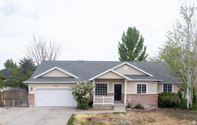 5094 W Pebblerock Cir S, West Jordan, UT 84081 - ranch-style home with brick siding, stucco siding, covered porch, an attached garage, and concrete driveway