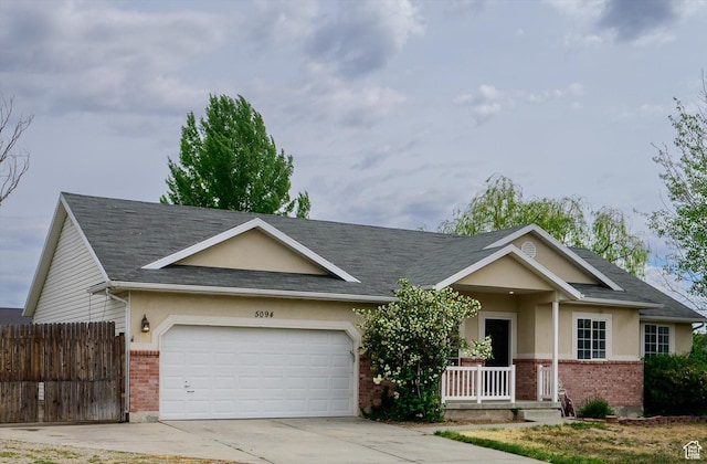 5094 W Pebblerock Cir S, West Jordan, UT 84081 - ranch-style house with brick siding, covered porch, a garage, concrete driveway, and stucco siding