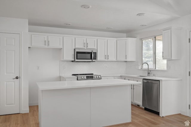 5094 W Pebblerock Cir S, West Jordan, UT 84081 - kitchen featuring appliances with stainless steel finishes, a sink, white cabinetry, a center island, and light wood finished floors