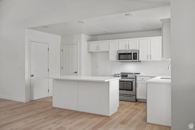 5094 W Pebblerock Cir S, West Jordan, UT 84081 - kitchen with appliances with stainless steel finishes, backsplash, light wood-type flooring, white cabinets, and recessed lighting