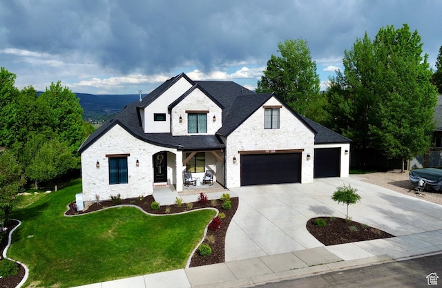 268 N 1400 W, Midway, UT 84049 - view of front of property with covered porch, driveway, a front yard, stone siding, and an attached garage