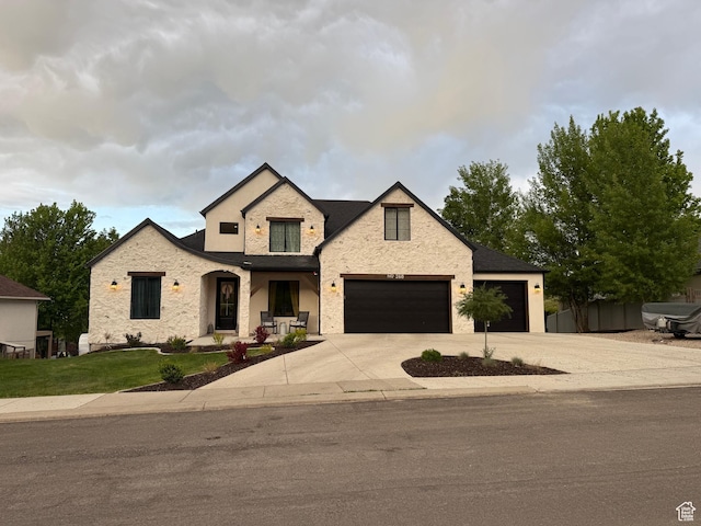 268 N 1400 W, Midway, UT 84049 - view of front facade featuring concrete driveway, stone siding, an attached garage, and a front lawn