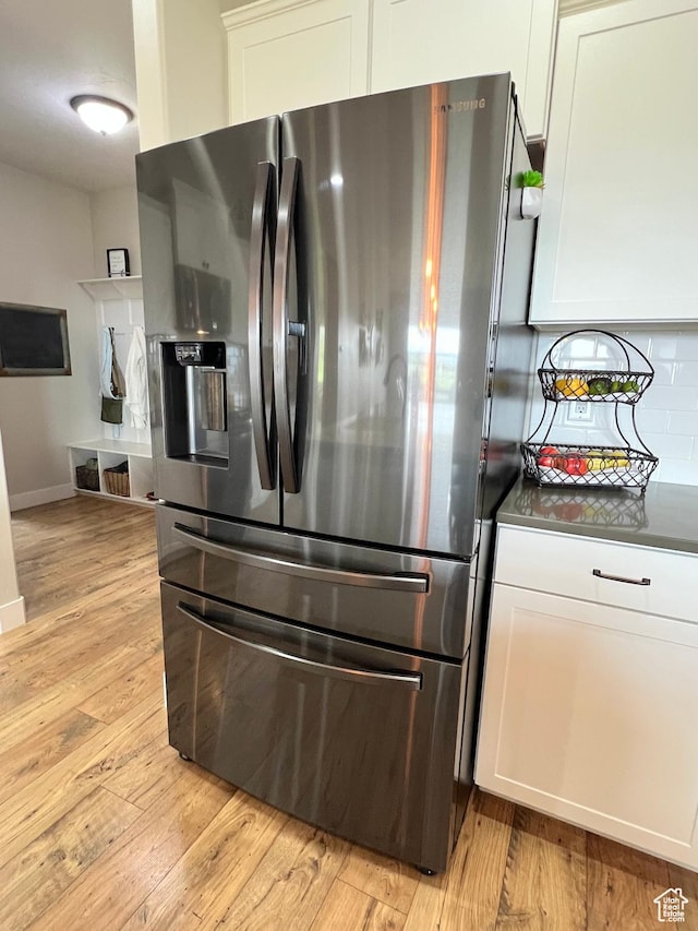 12137 N Montrose Dr, Highland, UT 84003 - kitchen featuring stainless steel fridge, dark countertops, backsplash, light wood-style flooring, and white cabinets