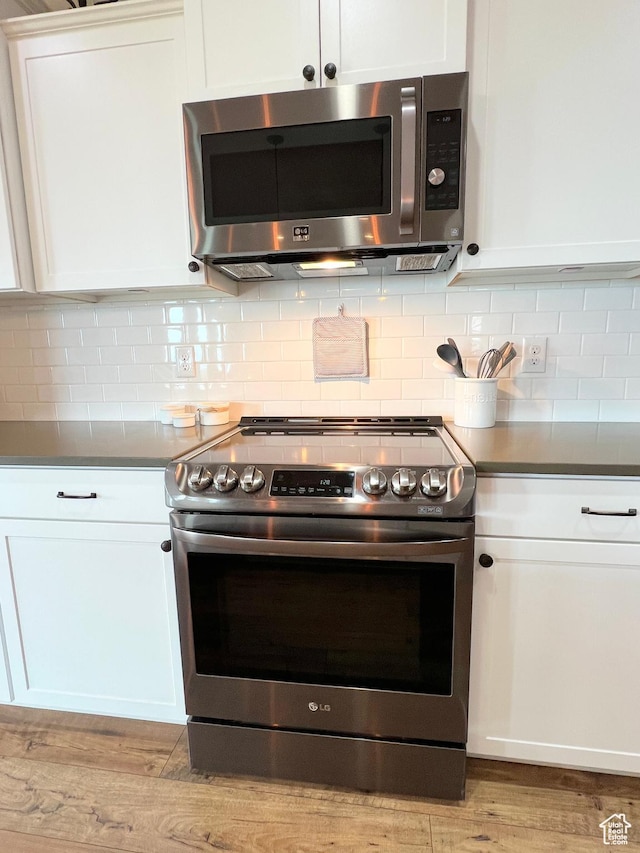 12137 N Montrose Dr, Highland, UT 84003 - kitchen featuring stainless steel appliances, white cabinetry, backsplash, and light wood-style flooring