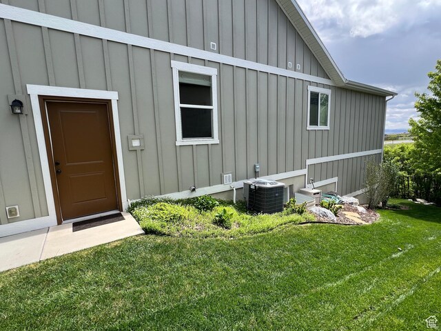 12137 N Montrose Dr, Highland, UT 84003 - doorway to property featuring board and batten siding, central AC, and a lawn