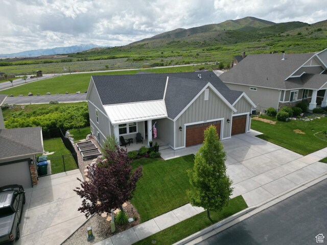 12137 N Montrose Dr, Highland, UT 84003 - view of front of house featuring a garage, board and batten siding, concrete driveway, a mountain view, and covered porch