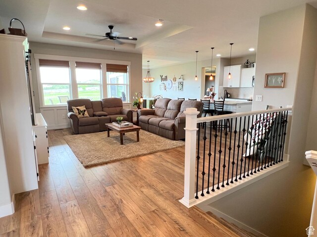 12137 N Montrose Dr, Highland, UT 84003 - living area featuring light wood-style flooring, a tray ceiling, ceiling fan, and recessed lighting