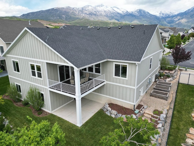 12137 N Montrose Dr, Highland, UT 84003 - back of property featuring a shingled roof, a mountain view, a patio area, board and batten siding, and a balcony