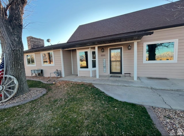 6692 S 3200 W, Benjamin, UT 84660 - rear view of property with a chimney, covered porch, a lawn, and roof with shingles