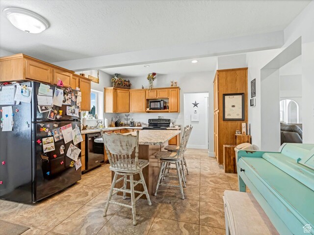 6692 S 3200 W, Benjamin, UT 84660 - kitchen with black appliances, open floor plan, a breakfast bar, a kitchen island, and light stone countertops