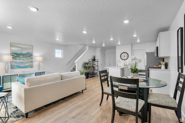 122 N Seaside St Unit 2319, Saratoga Springs, UT 84045 - dining space with stairway, recessed lighting, light wood-style flooring, and a textured ceiling