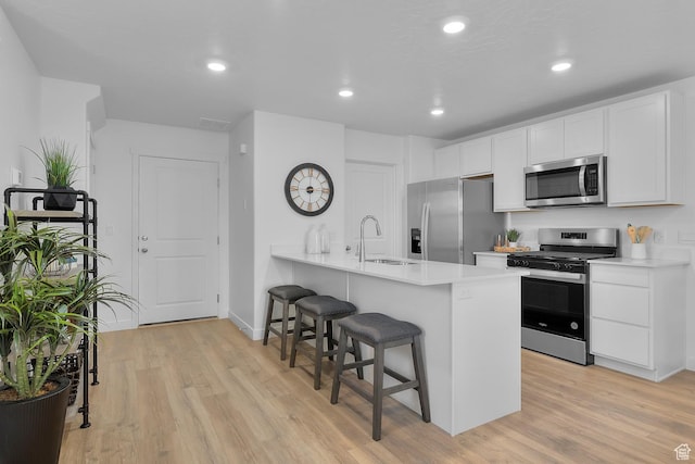 122 N Seaside St Unit 2319, Saratoga Springs, UT 84045 - kitchen with appliances with stainless steel finishes, a sink, a breakfast bar area, light wood-style flooring, and recessed lighting