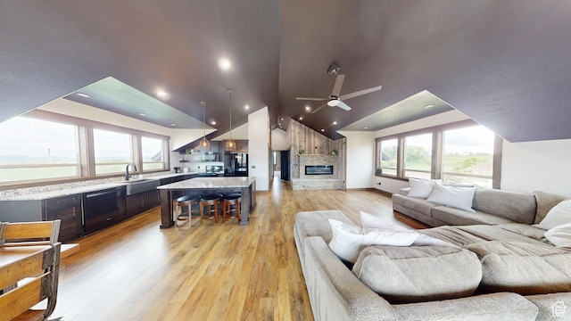 1164 S 1600 E, Preston, ID 83263 - living area featuring vaulted ceiling, ceiling fan, light wood finished floors, healthy amount of natural light, and a stone fireplace