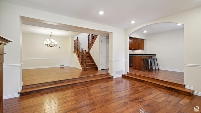 3263 Shadowbrook Cir N, Provo, UT 84604 - unfurnished living room featuring hardwood / wood-style flooring, stairs, arched walkways, recessed lighting, and a chandelier