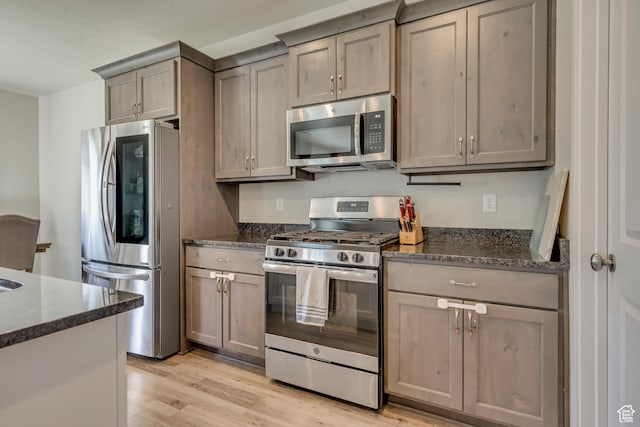 2466 S 2200 W, West Haven, UT 84401 - kitchen with appliances with stainless steel finishes, light wood-type flooring, dark stone counters, and gray cabinets