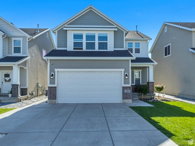 2466 S 2200 W, West Haven, UT 84401 - view of front of house featuring brick siding, a garage, driveway, and a front lawn