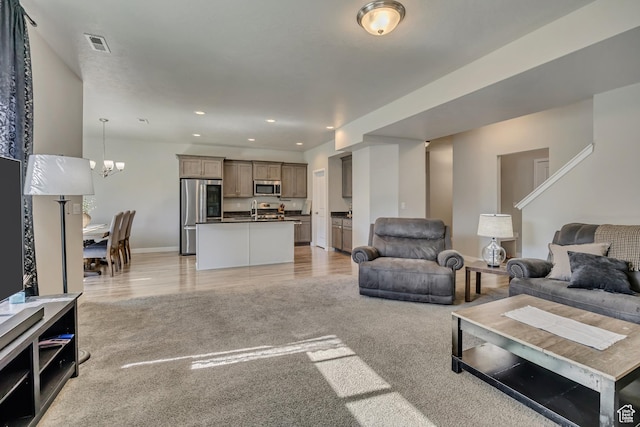 2466 S 2200 W, West Haven, UT 84401 - living room with recessed lighting, a chandelier, baseboards, light wood-type flooring, and light colored carpet