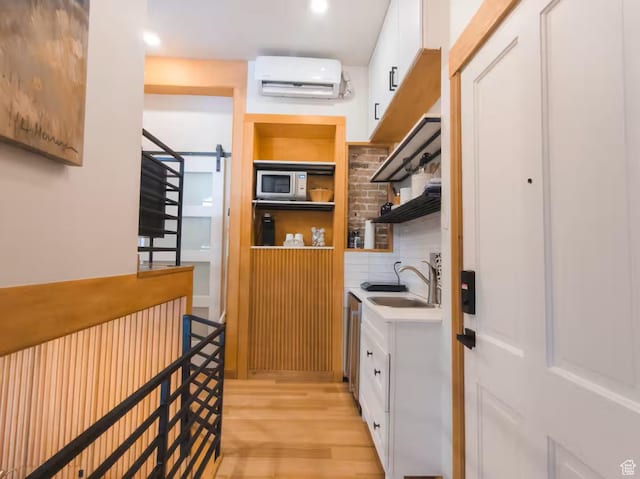 161 W 200 S, Provo, UT 84601 - laundry room featuring a sink, an AC wall unit, and light wood-style flooring
