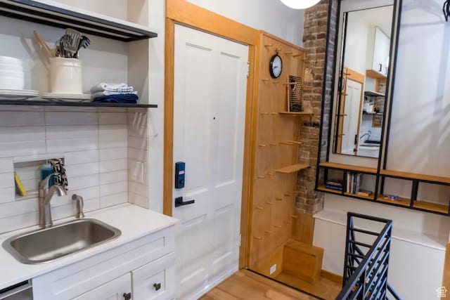 161 W 200 S, Provo, UT 84601 - kitchen with a sink, backsplash, light wood-style flooring, light countertops, and white cabinetry