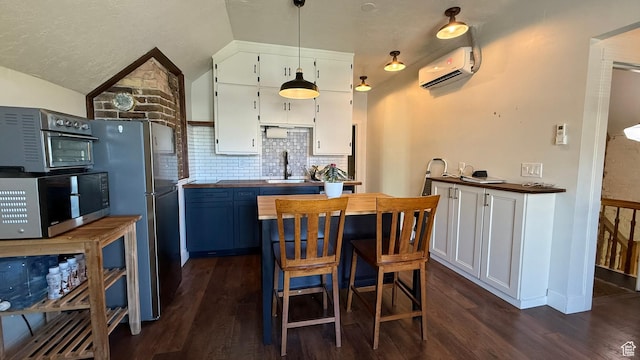 161 W 200 S, Provo, UT 84601 - kitchen with stainless steel appliances, an AC wall unit, dark wood-style floors, white cabinets, and lofted ceiling