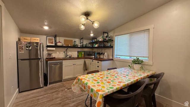 161 W 200 S, Provo, UT 84601 - kitchen featuring stainless steel appliances, a sink, a textured ceiling, white cabinets, and light wood finished floors