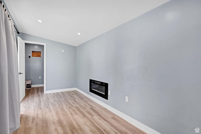 181 W 400 S, Hyrum, UT 84319 - unfurnished living room featuring light wood-style flooring, baseboards, recessed lighting, and a glass covered fireplace