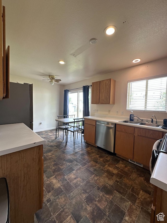 853 S 860 W, Tooele, UT 84074 - kitchen featuring appliances with stainless steel finishes, light countertops, a sink, dark stone finish flooring, and a textured ceiling