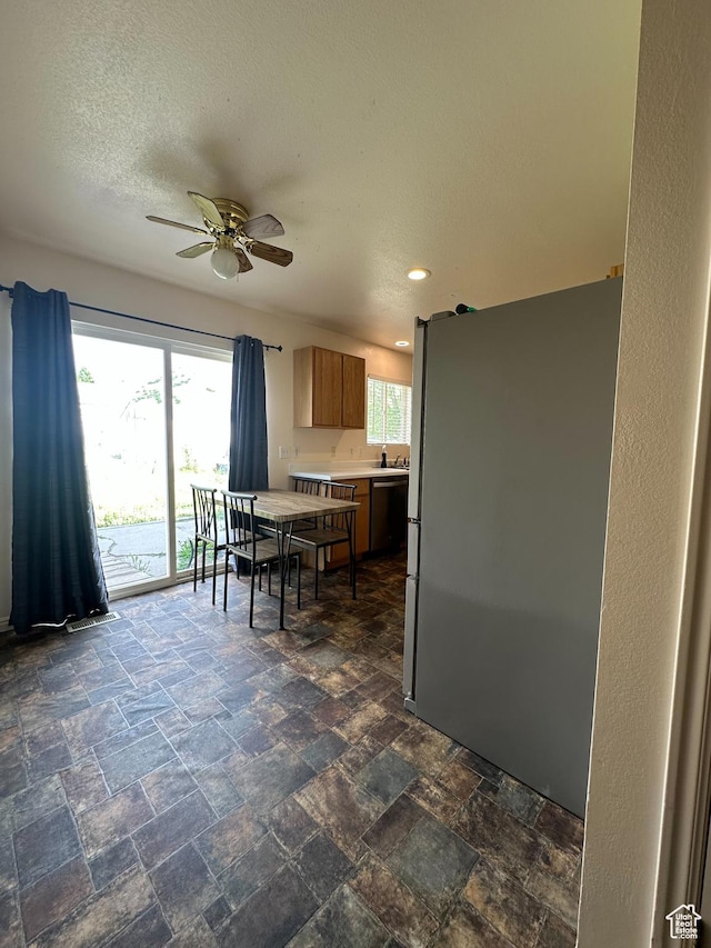853 S 860 W, Tooele, UT 84074 - kitchen featuring freestanding refrigerator, dishwasher, a ceiling fan, light countertops, and dark stone finish flooring