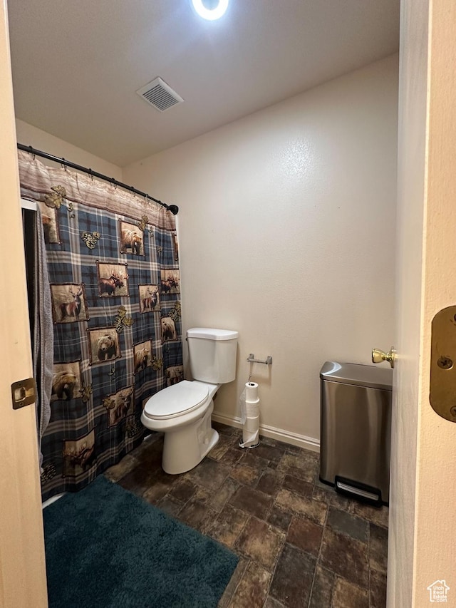 853 S 860 W, Tooele, UT 84074 - full bathroom featuring toilet, stone finish floors, and a shower with shower curtain