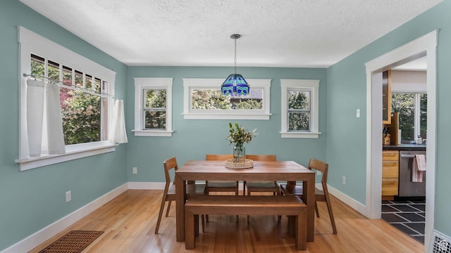2504 S Dearborn St E, Salt Lake City, UT 84106 - dining space featuring light wood-style flooring, plenty of natural light, a textured ceiling, and baseboards