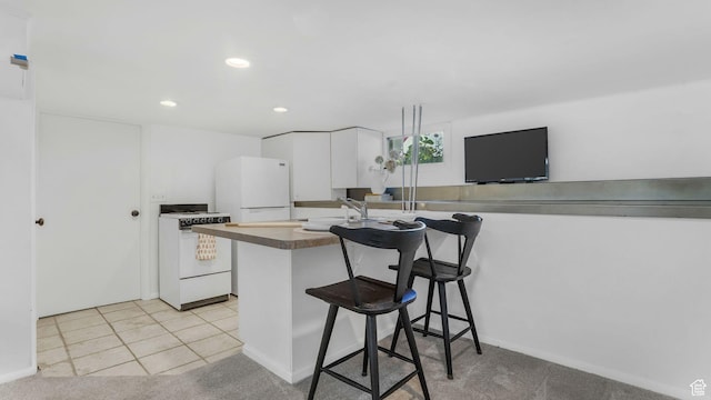 2504 S Dearborn St E, Salt Lake City, UT 84106 - kitchen featuring white appliances, white cabinets, a kitchen breakfast bar, recessed lighting, and light colored carpet