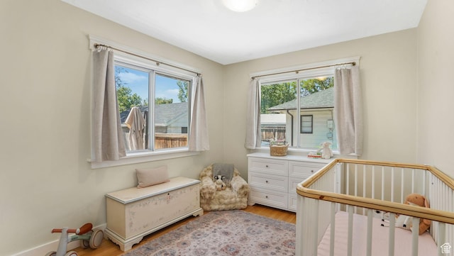 2504 S Dearborn St E, Salt Lake City, UT 84106 - bedroom with light wood-style flooring and a crib