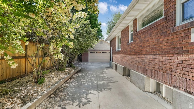 2504 S Dearborn St E, Salt Lake City, UT 84106 - view of side of property featuring brick siding, an outbuilding, a garage, and concrete driveway