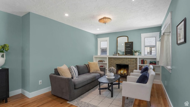 2504 S Dearborn St E, Salt Lake City, UT 84106 - living room with a textured ceiling, light wood-style flooring, baseboards, and a brick fireplace
