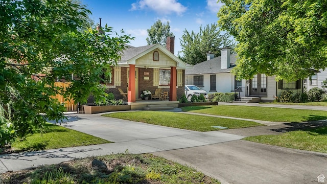 2504 S Dearborn St E, Salt Lake City, UT 84106 - view of front of home with brick siding, a front yard, a chimney, french doors, and covered porch