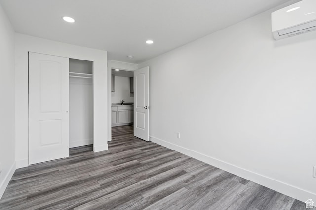 2092 N Red Yearling Dr, Saratoga Springs, UT 84045 - unfurnished bedroom with a wall unit AC, recessed lighting, baseboards, dark wood-style flooring, and a closet