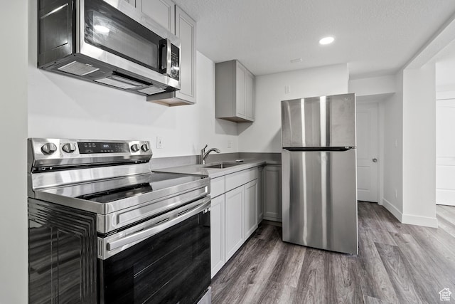 2092 N Red Yearling Dr, Saratoga Springs, UT 84045 - kitchen featuring appliances with stainless steel finishes, a sink, wood finished floors, a textured ceiling, and recessed lighting