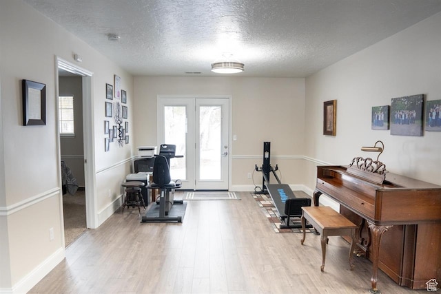 731 Pioneer Dr, Soda Springs, ID 83276 - exercise room featuring light wood-type flooring, a textured ceiling, and baseboards