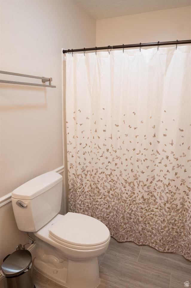 731 Pioneer Dr, Soda Springs, ID 83276 - full bath featuring toilet, wood finished floors, and a shower with curtain