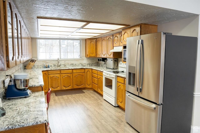 731 Pioneer Dr, Soda Springs, ID 83276 - kitchen featuring stainless steel refrigerator with ice dispenser, electric stove, brown cabinetry, under cabinet range hood, and light wood-style floors