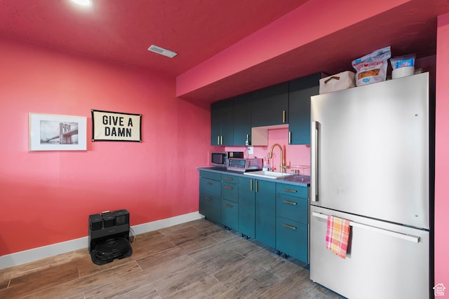 2335 W Cresthaven Ln, Lehi, UT 84043 - kitchen with freestanding refrigerator, a sink, wood finished floors, and baseboards